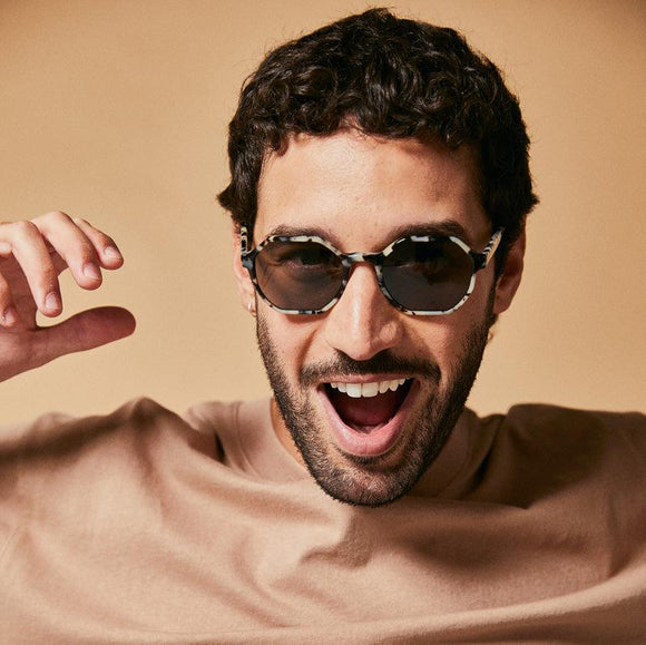 Male model wearing black and white polarised sunglasses from Ozeano 