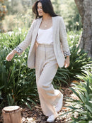 Woman in a beige suit walking through a garden